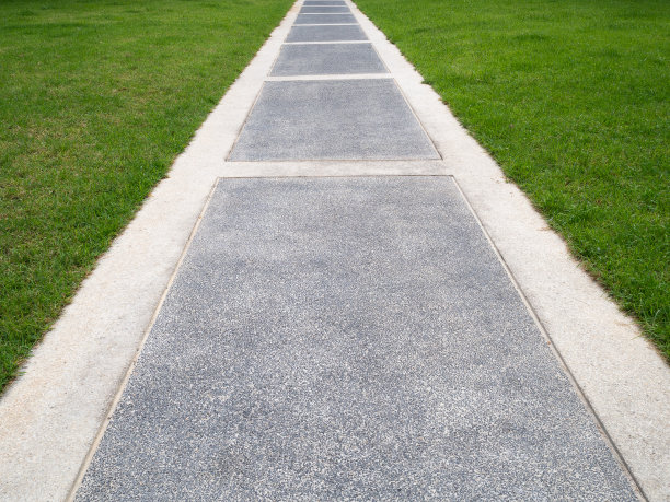 明亮的绿色草地和人行道作为背景墙纸图片下载