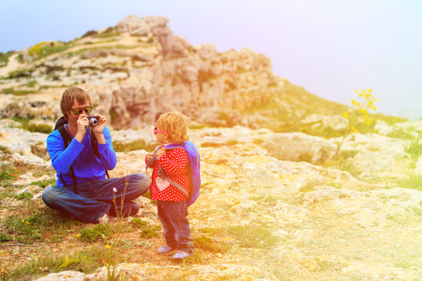 父亲在拍摄小女儿爬山时的照片图片下载