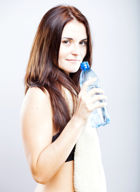 年轻女子健身后用毛巾和水瓶图片下载