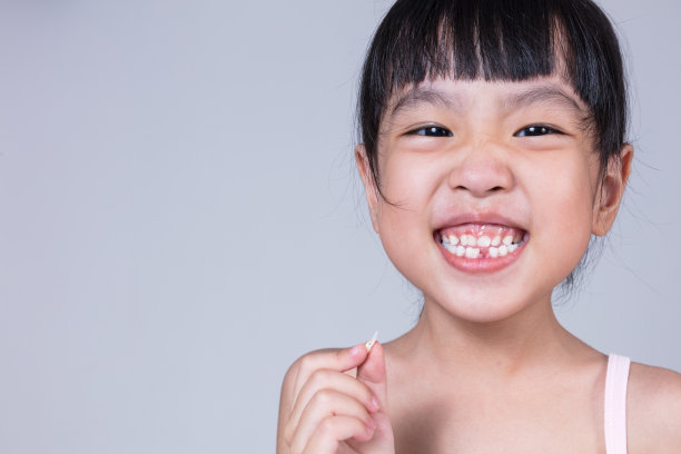 亚洲华人小女孩，拿着她缺牙图片下载