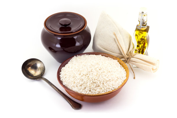 将米粒放在一个粘土堆里，旁边是一个陶罐和一个铜勺，素材图片