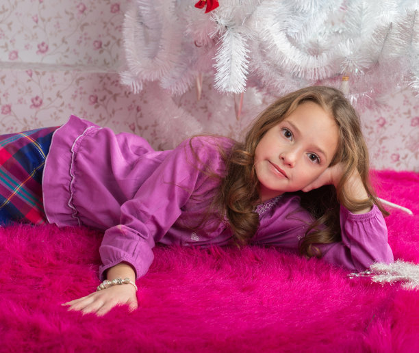 女孩躺在粉红色的地毯上图片下载