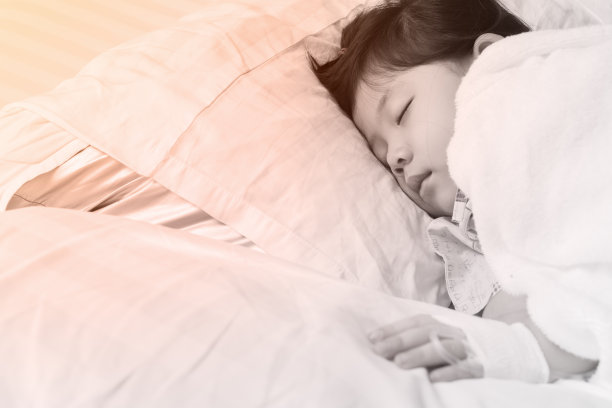 亚洲小女孩手拿盐水给生病的孩子。图片下载