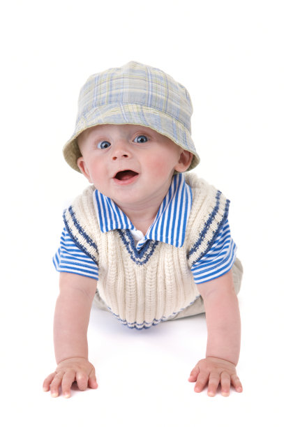 可爱的微笑婴儿男孩戴着帽子爬在白色的背景图片下载