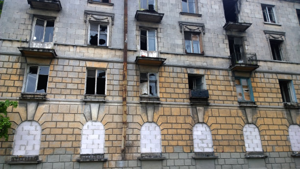 废弃的破旧的旧住宅楼。窗户破了，用木板封住了图片下载