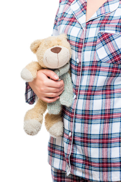 泰迪熊在一个女孩的手在一个白色的背景特写图片下载