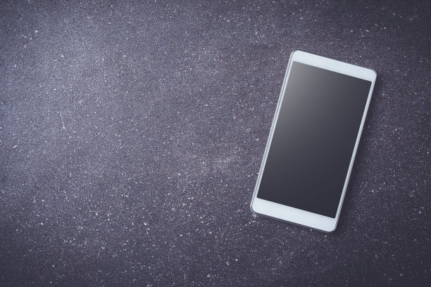 黑色的石头桌上放着白色的智能手机图片下载