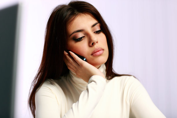 年轻沉思的女人正在讲电话图片下载