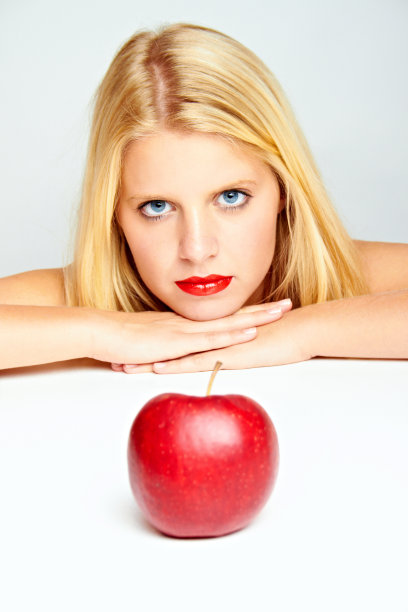 白底上戴着红苹果的金发女郎图片下载