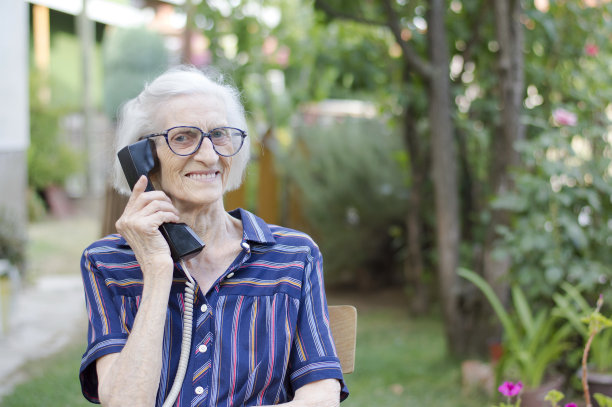 快乐的老妇人在后院打电话图片下载