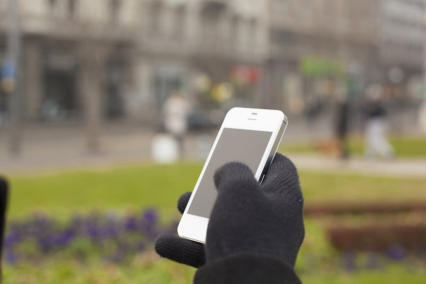 带有模糊背景的手套手持手机图片下载