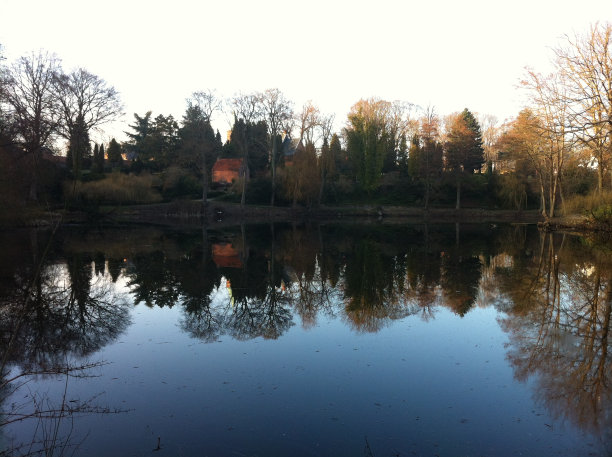 房子在一个公园里，有一个湖和它的倒影。图片下载