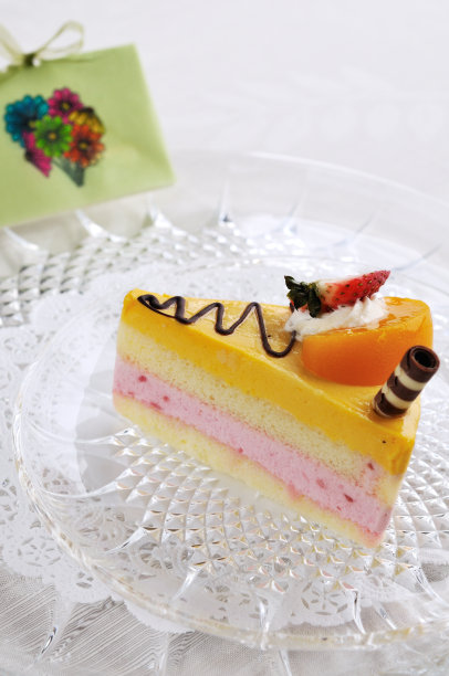 桌上有一张卡片，上面有草莓和芒果奶酪蛋糕图片下载