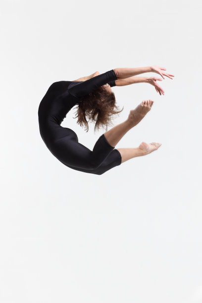 女舞者跳跃并触摸脚趾图片下载