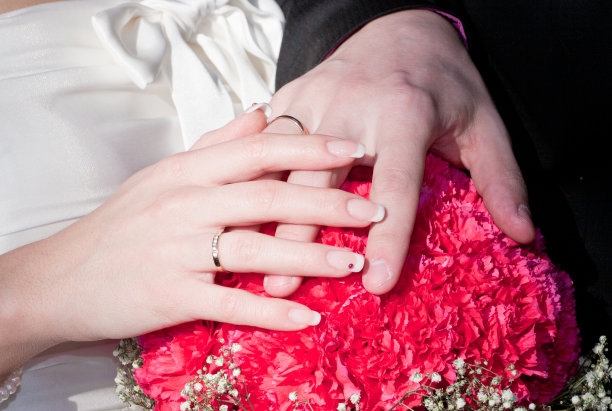 新婚夫妇的手与戒指在花束图片下载