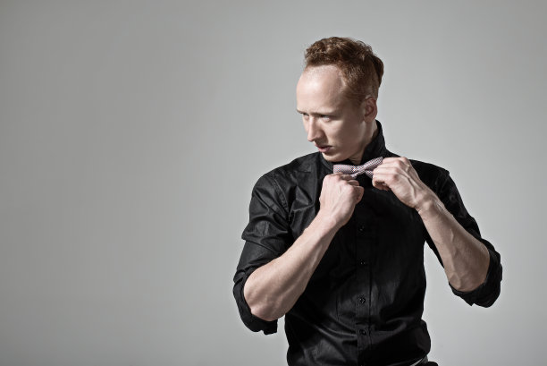 打着领结的帅气小伙子。工作室时尚肖像。图片下载