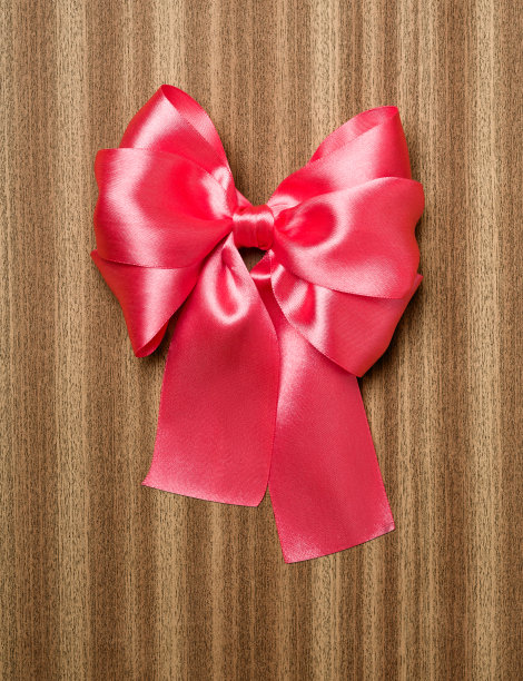 木制背景上的红色蝴蝶结图片下载