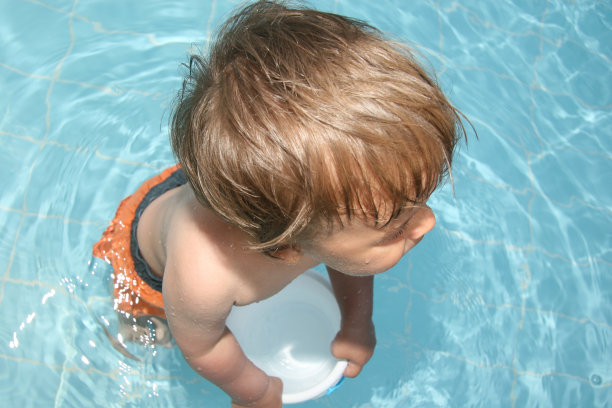 小男孩拿着水桶在游泳池里图片下载