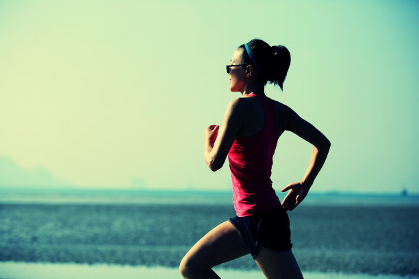 年轻女子在海滩上跑步图片下载