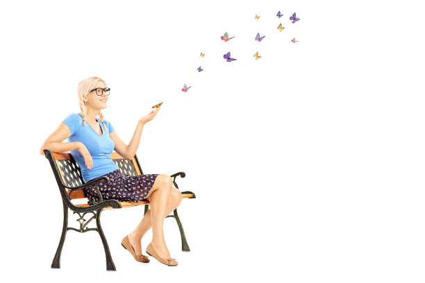 年轻的雌性坐在长凳上，看着五颜六色的蝴蝶图片下载