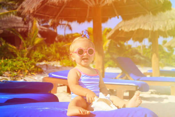 可爱的小女孩和贝壳在热带海滩上图片下载