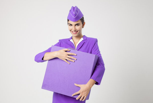 穿着紫色制服和手提箱的迷人空姐图片下载