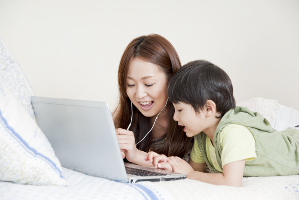 一个亚洲家庭，有一台笔记本电脑素材图片