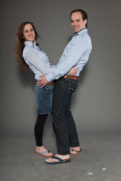 灰色背景下的幸福年轻夫妇。时尚风格的工作室肖像。图片下载