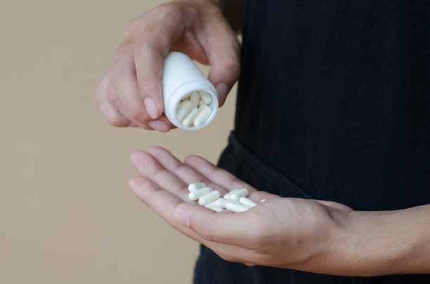 手拿白色包装和药丸的图片图片下载