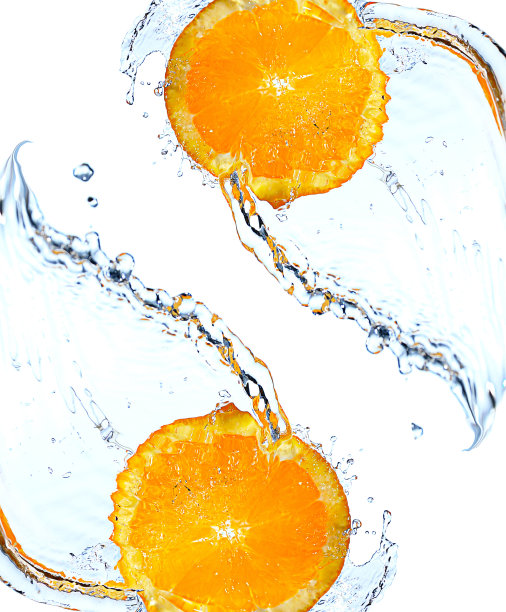 橙子片掉落并溅入清澈的水中。图片下载