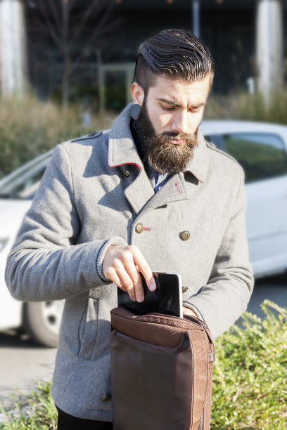年轻的潮人商人查看他的笔记本电脑图片下载