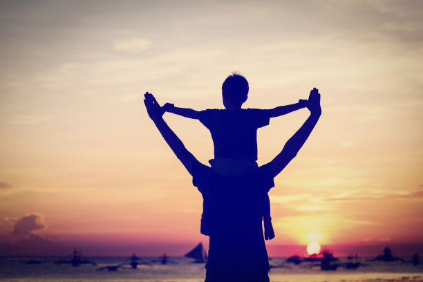 日落海滩上快乐的父子俩图片下载