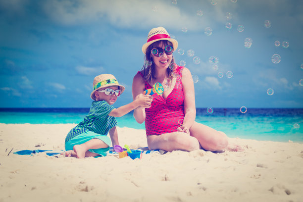 母亲和儿子在海滩上制造肥皂泡图片下载