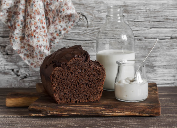 巧克力蛋糕，牛奶瓶，酸奶在乡村木制背景图片下载