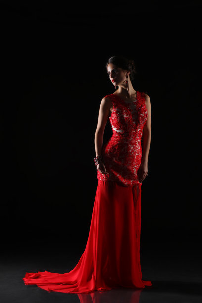 穿红衣服的年轻美女。孤立在黑色背景上图片下载