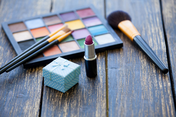 木桌上有礼品盒和化妆刷。图片下载