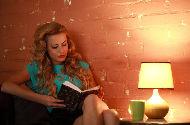 美丽的女人在舒适的咖啡馆里看书图片下载