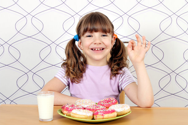 快乐的小女孩有甜甜圈和ok的手势图片下载