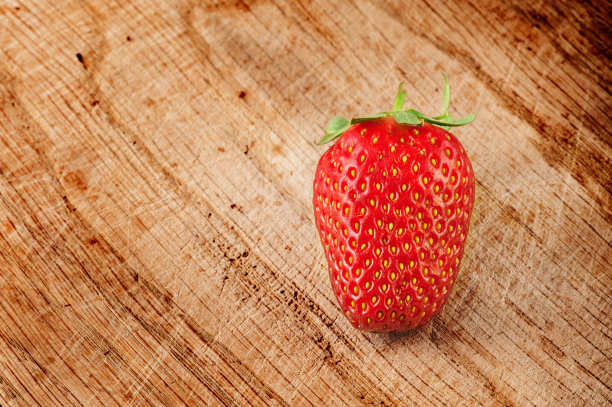 草莓放在木砧板上图片下载