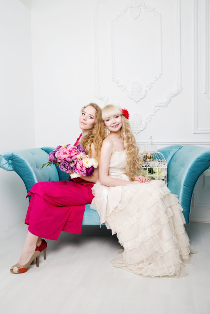 漂亮的年轻女孩坐在蓝色的沙发上图片下载