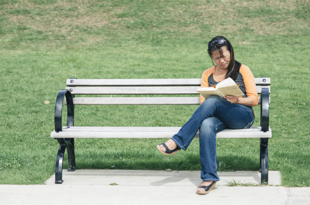 在公园长椅上看书的女人图片下载