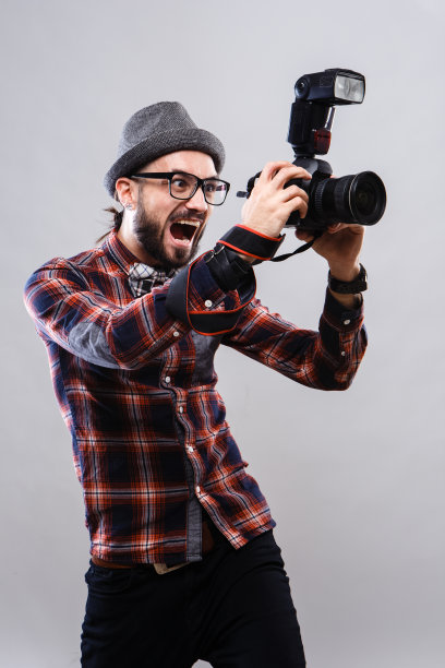 魅力非凡的摄影记者，戴着眼镜，穿着格子衬衫图片下载