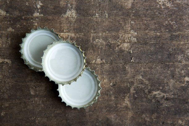 瓶盖在质朴的木制背景上图片下载