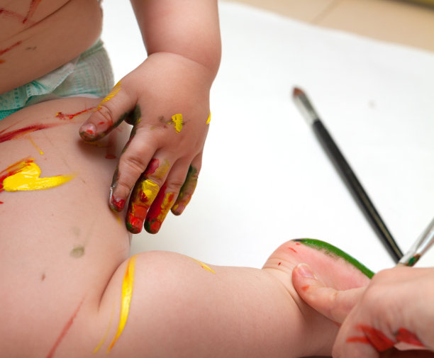 靠近婴儿的腿和手覆盖油漆图片下载