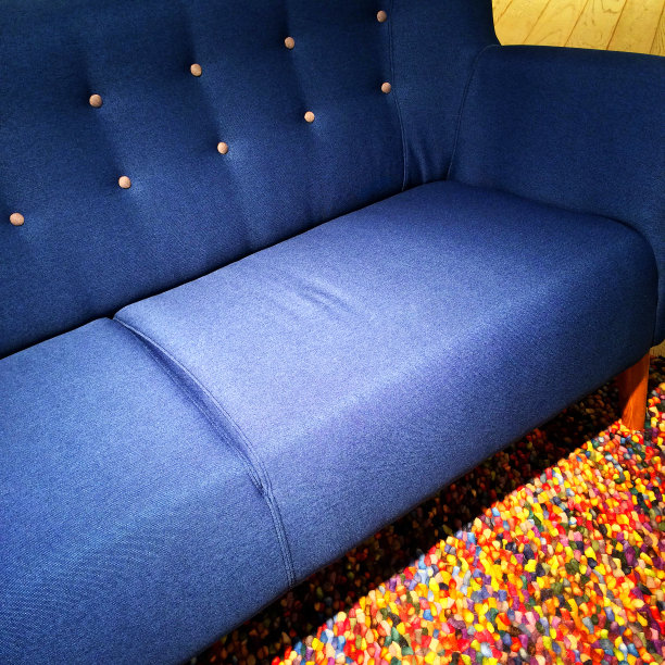 蓝色的纺织沙发上的彩色地毯图片下载