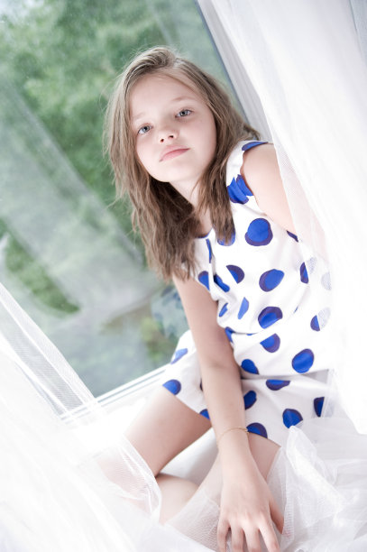 小女孩坐在窗户上。图片下载
