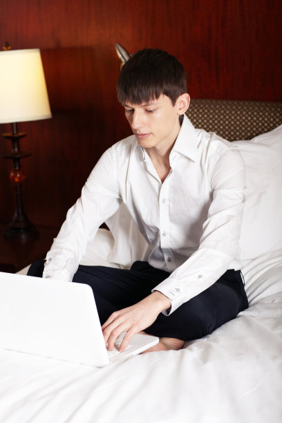 年轻的商人在酒店用笔记本电脑工作图片下载