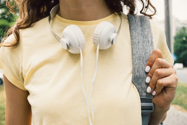 一个女孩在黄色t恤和耳机的特写图片下载