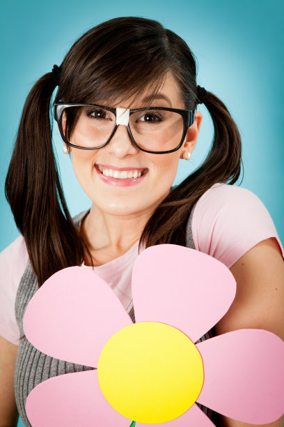 在异想天开的户外世界里，快乐的书呆子女孩捧着花图片下载