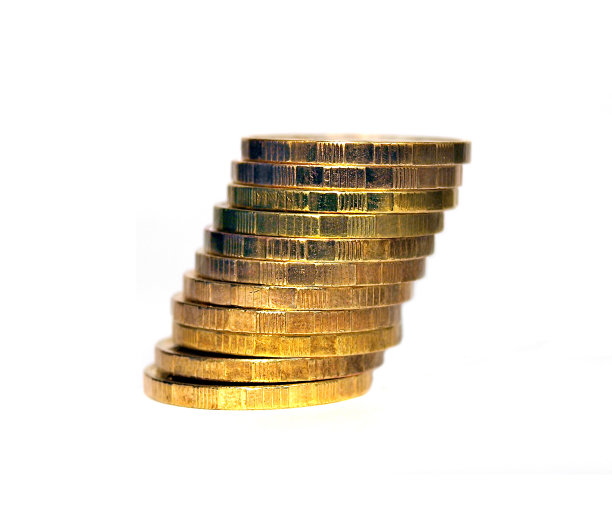 倾斜的一堆金币在白色的背景上图片下载